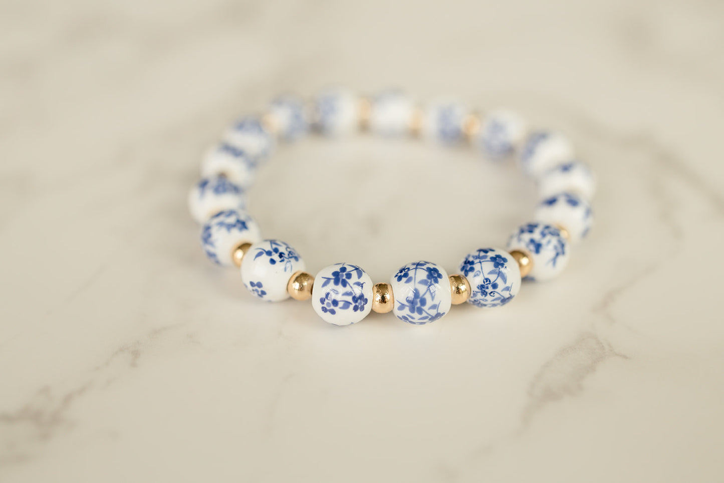 Blue Blossom Bracelet adorned with blue and white flowered beads on a light background