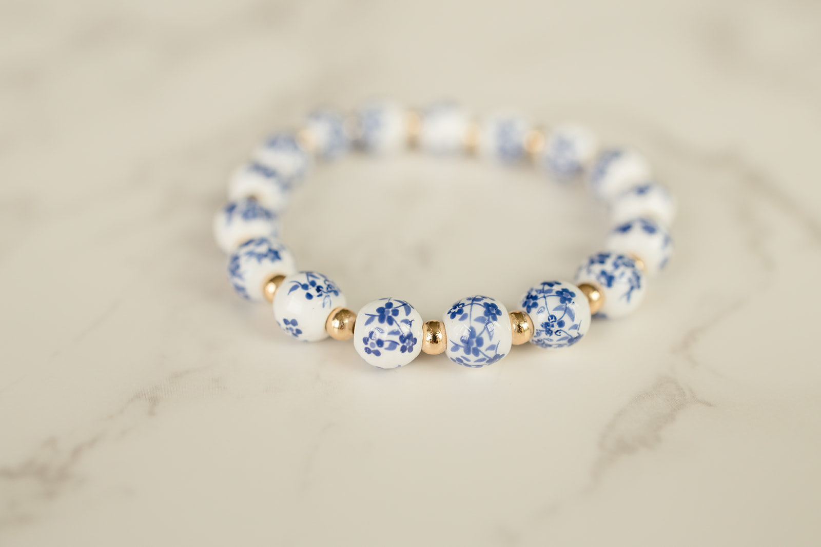 Blue Blossom Bracelet adorned with blue and white flowered beads on a light background