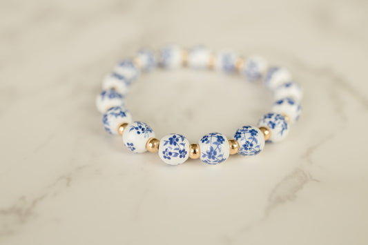 Blue Blossom Bracelet adorned with blue and white flowered beads on a light background