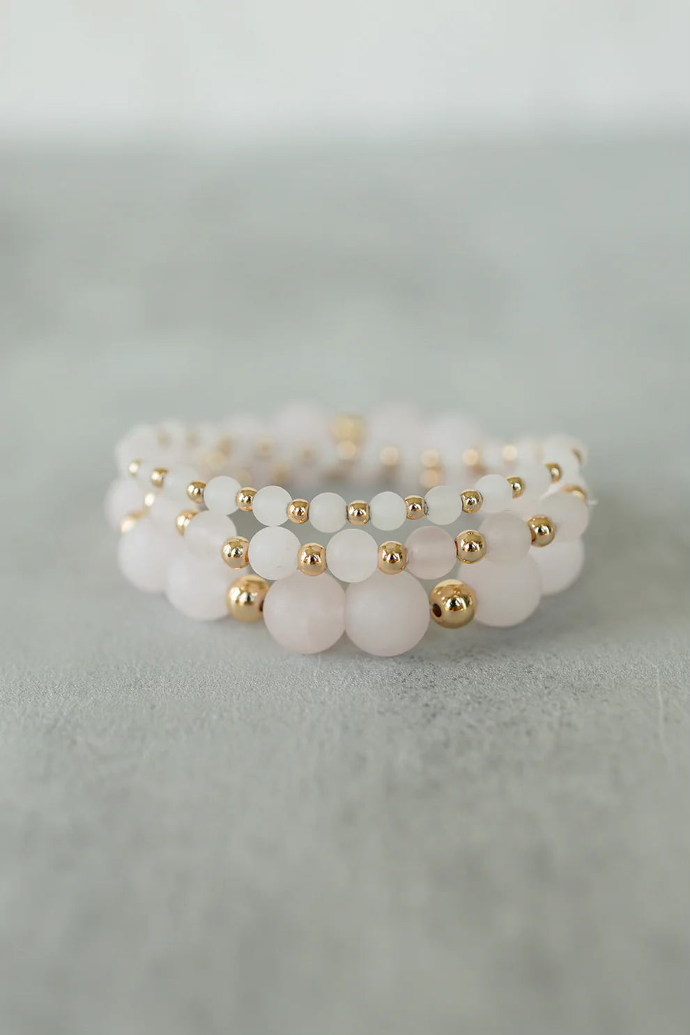 a stack of quartz blush bracelets 
